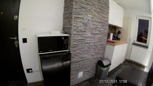 eine Küche mit einer Backsteinwand und einer Mikrowelle in der Unterkunft Hotel Marasesti in Buşteni