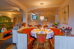 un comedor con una mesa blanca y sillas naranjas en Landgasthof Geiersmühle, en Vielbrunn