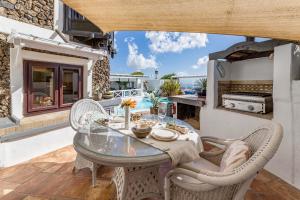 a patio with a table and chairs and a kitchen at Deluxe designer historic villa Via Lactea, Panoramic sea views, Own private heated pool and subtropical garden in La Asomada