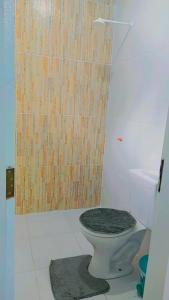 a bathroom with a toilet with a wooden wall at Casa Azul in Barreirinhas