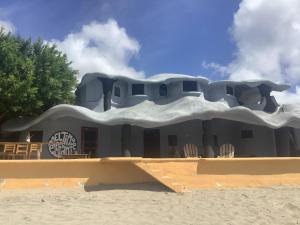 - un bâtiment sur la plage avec des chaises en face dans l'établissement Melting Elefante, à Popoyo