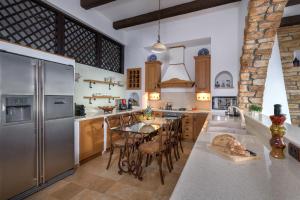 a kitchen with a stainless steel refrigerator and a table at Villa Haraki Paradise in Haraki
