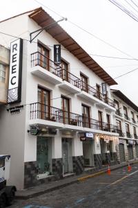 a white building with a balcony on the side of it at REEC Latacunga by Oro Verde Hotels in Latacunga