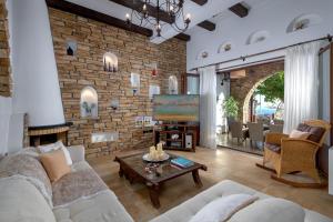 a living room with a couch and a brick wall at Villa Haraki Paradise in Haraki