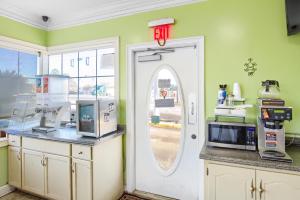 a kitchen with a door with an exit sign on it at Adams Inn in Dothan