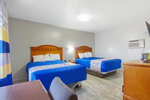 a hotel room with two beds and a table at Adams Inn in Dothan