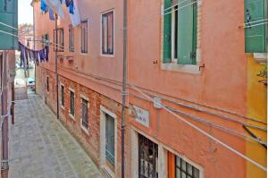 un callejón en una ciudad con edificios naranjas en DolceVita Apartments N 285 en Venecia