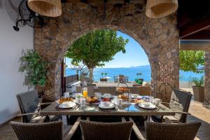 an outdoor dining table with a view of the ocean at Villa Haraki Paradise in Haraki