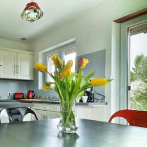 a vase of yellow tulips on a table in a kitchen at COTTAGE-GITE COEUR DE SUNDGAU in Leymen