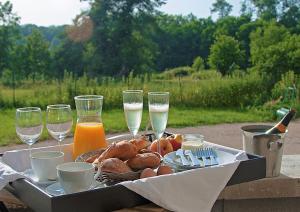 a table with a plate of food and glasses of wine at L'Arbre à Cabane in Guyonvelle