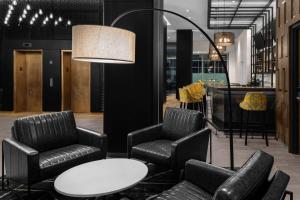 a lobby with chairs and a table and a lamp at voco Times Square South New York, an IHG Hotel in New York