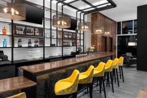 a bar with yellow chairs at a restaurant at voco Times Square South New York, an IHG Hotel in New York