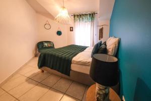 1 dormitorio con 1 cama y 1 silla en una habitación en L'escapade, maison de village classée meublé de tourisme 4 étoiles, en Marseillan