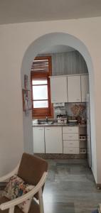 een keuken met witte kasten en een stoel in een kamer bij Casa Típica Cordobesa in Córdoba