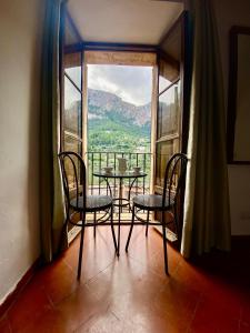 a table and chairs in a room with a large window at Hostal Villa Verde-Adults Only in Deia