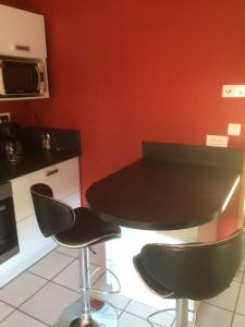 une cuisine avec une table noire et deux chaises dans l'établissement Le Coin Tranquille au pied du Puy de Dôme, à Pontgibaud