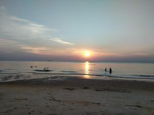 un groupe de personnes jouant dans l'eau à la plage dans l'établissement Budget 2-Bedroom@Cocobay Resort Condominium, à Port Dickson