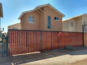 a red fence in front of a house at Casa La Florida in La Serena