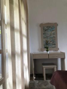 a bedroom with a table and a mirror and a window at Blue Garden Inn in Fourka