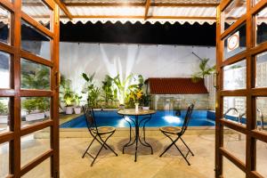 Habitación con mesa, sillas y piscina en OV Private Pool Villas near Baga, I 4BHK units I Staff en Calangute