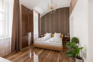 een slaapkamer met een bed en een kroonluchter bij Luxury Dream Home at The Basilica 3BR/2BATH in Boedapest