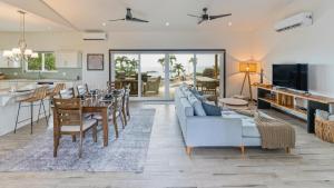 a living room with a blue couch and a dining room at Stunning Mountaintop Property with Stylish Main Home, Private Guesthouse & Infinity Pool in Santa Cruz