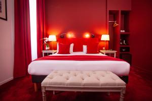 a red bedroom with a large bed with red pillows at Hôtel Churchill Bordeaux Centre in Bordeaux