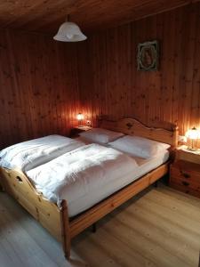 Cette chambre en bois comprend un grand lit. dans l'établissement Appartamenti Bozzetta Marisa, à Cavalese