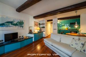 een woonkamer met een bank en een keuken bij Casa Smeraldo by PortofinoVip in Portofino