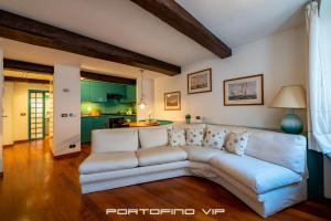 een woonkamer met een witte bank en een keuken bij Casa Smeraldo by PortofinoVip in Portofino