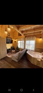 Großes Zimmer mit einer großen Badewanne und einem Wohnzimmer. in der Unterkunft Vida Bhermon 1, one wood Cabin in Madschdal Schams