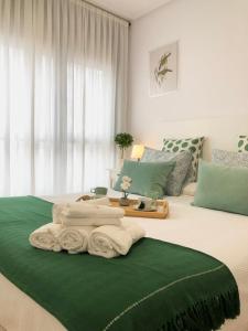 ein Schlafzimmer mit einem Bett mit Handtüchern darauf in der Unterkunft Apto2 Céntrico Frentebahía Garaje Incluido in Castro-Urdiales
