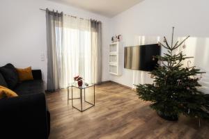 a living room with a christmas tree and a couch at Ferienwohnung Bergäcker in Neualbenreuth