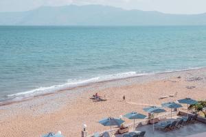 a beach with chairs and umbrellas and the ocean at Galini Beach Hotel in Kissamos