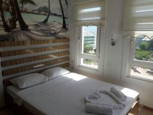 a bedroom with two towels on a bed with two windows at PEARL OF MARMARIS in Marmaris