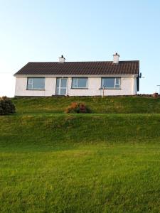 a house on top of a grassy hill at Maggie's House in Glenties