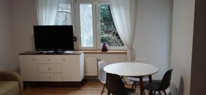 a small living room with a table and a tv at Apartament OLIVER in Świnoujście