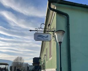 un cartello sul lato di un edificio con un lampione di HAUS-DONAU in der Wachau ad Aggsbach