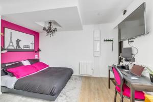sypialnia z różowym łóżkiem i biurkiem w obiekcie Studio le petit baroque w mieście Chevilly-Larue