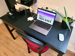 een zwart bureau met een laptop erop bij Studio le petit baroque in Chevilly-Larue