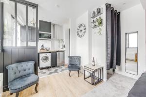 a living room with a couch and a chair and a table at Studio le petit baroque in Chevilly-Larue