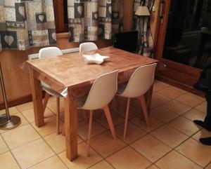 a wooden table with four chairs around it at Rez de chaussée très calme vue Mont-Blanc in Combloux