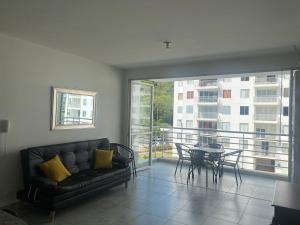 een woonkamer met een bank en een tafel op een balkon bij Apartamento Conjunto Aqualina Orange in Girardot