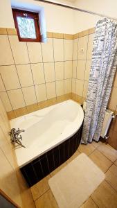 a bath tub in a bathroom with a window at Bogyólak Palkonya in Palkonya
