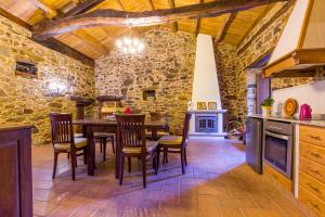 a kitchen with a table and chairs and a stone wall at A casa de López in A Coruña