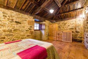 a bedroom with a bed in a stone building at A casa de López in A Coruña