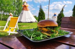 a sandwich on a plate on a wooden table at Osada Indiańska in Ostrów Podlaski