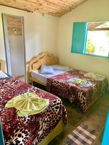 Habitación con 2 camas y sábanas de leopardo. en Pousada Shangrilá São Thomé, en São Thomé das Letras 86 fotos más