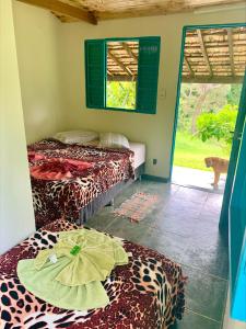 Habitación con 2 camas en una habitación con ventana en Pousada Shangrilá São Thomé, en São Thomé das Letras