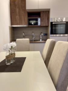 a white table with chairs and a vase of flowers on it at Milmari N69 in Kopaonik
